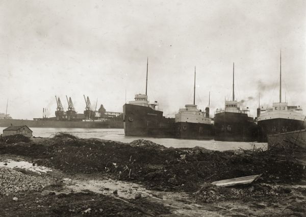 View of docks with ships tied up for the winter. The Reiss coal yard is in the background.