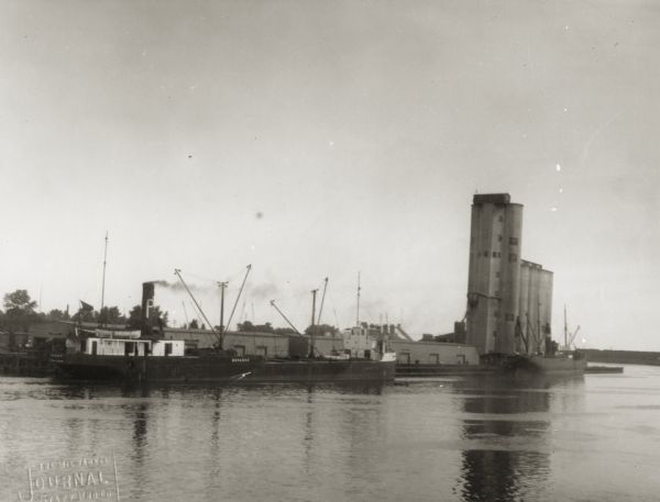 View across water towards a grain elevator on the site of the old Elmore & Kelly's elevator.