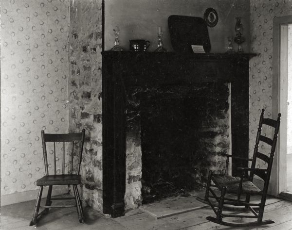 Interior view of the Tank cottage featuring a fireplace and two rocking chairs.