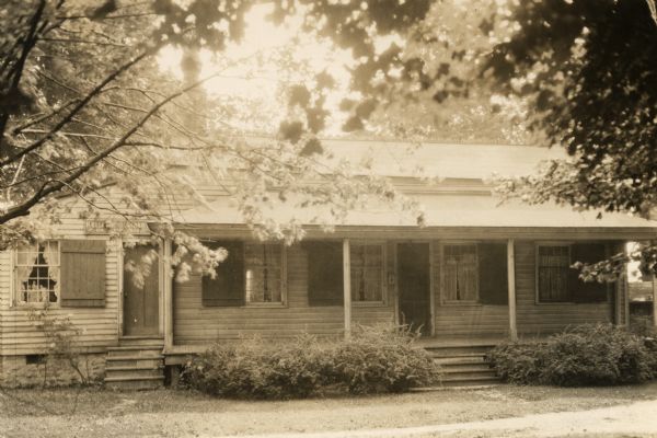 Close-up view of the cottage when it was a library. A sign is partly visible on the building stating: "Kellogg Public Library, Union Park Branch." Used as a museum and the Kellogg Public Library, Union Park Branch, Union Park (the name was later changed to Tank Park in 1920).  The building was moved to Heritage Hill State Park in 1974.