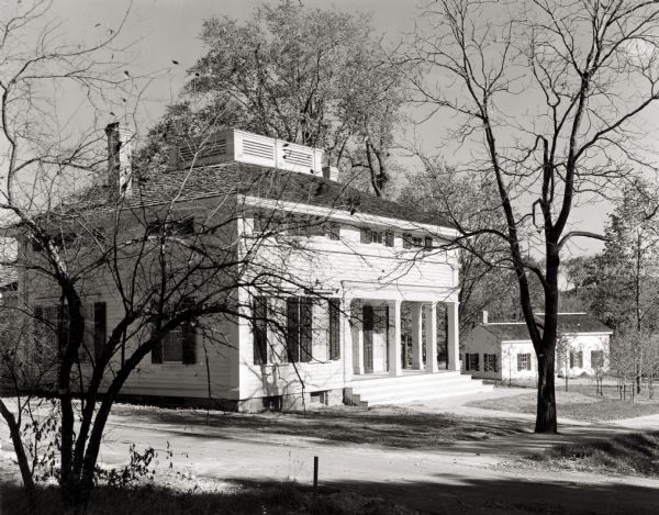 View of the Butternut House in the Kohler Foundation restoration project. The service building at the right in the background is operated by the Conservation Department. The Butternut House was the residence of Sylvanus Wade's eldest daughter and her husband.