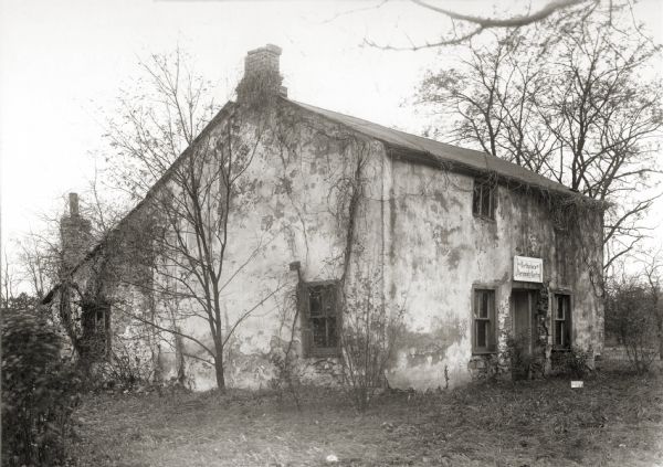 Southwest view of the Jeremiah Curtin house at 8685 West Grange Avenue. This stone and stucco residence was erected in 1835. It has been recognized as the boyhood home of linguist and mythologist Jeremiah Curtin.  A sign above the doorway reads: "Birthplace of Jeremiah Curtin".