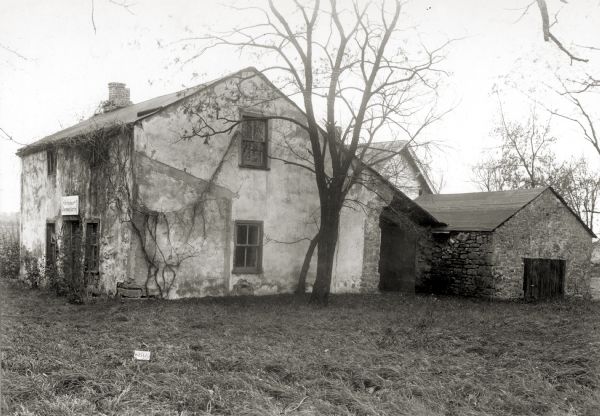 Southeast view of the Jeremiah Curtin house located at 8685 West Grange Avenue. This stone and stucco residence was erected in 1835. It has been recognized as the boyhood home of linguist and mythologist Jeremiah Curtin. A sign above the doorway reads: "Birthplace of Jeremiah Curtin".