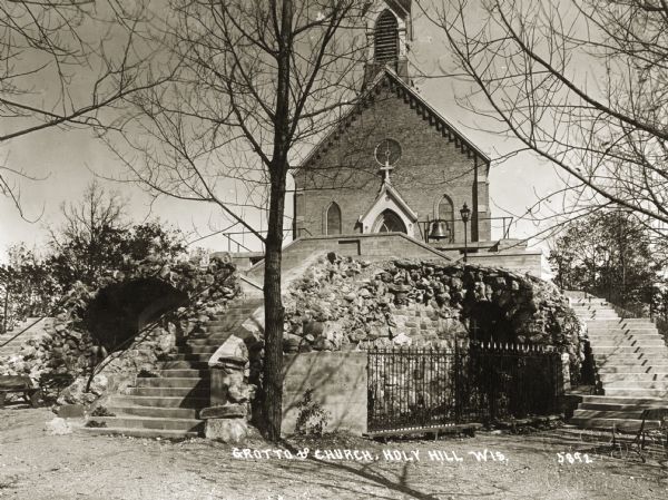View of the Carmelite Church of Our Lady, Help of Christians and the nearby grotto. Caption reads: "Grotto of Church, Holy Hill Wis."