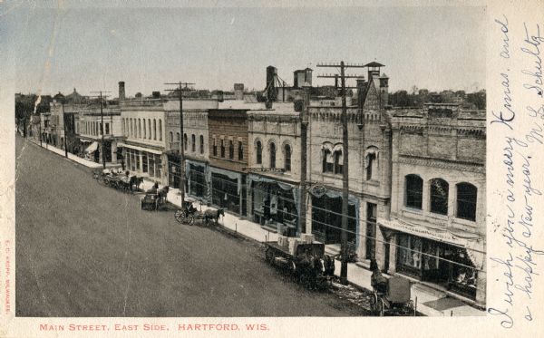 Elevated view towards the right side of Main Street. Caption reads: "Main Street, East Side, Hartford, Wis."