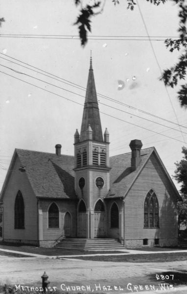 View across street towards a Methodist church. Caption reads: "Methodist Church, Hazel Green, Wis."