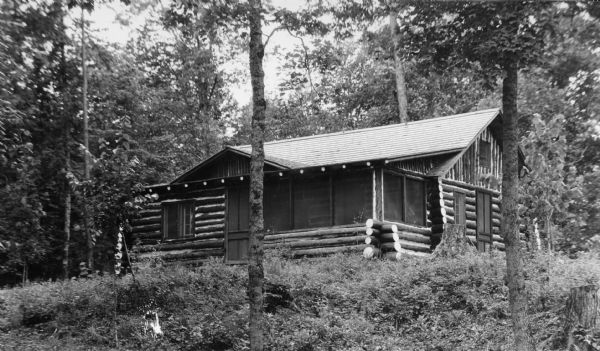 View of a Hilbert Lake cottage surrounded by trees and foliage.
