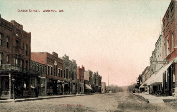 View down street with businesses and storefronts on both sides. Caption reads: "Center Street, Wonewoc, Wis."