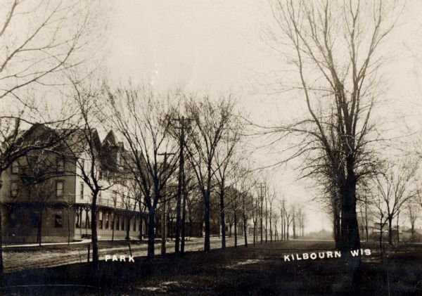 Park in Wisconsin Dells. A large building is across the street on the left. Caption reads: "Kilbourn Wis".