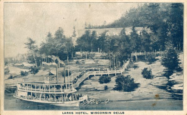 Elevated view across water toward the Larks Hotel and ferry. Caption reads: "Larks Hotel, Wisconsin Dells."