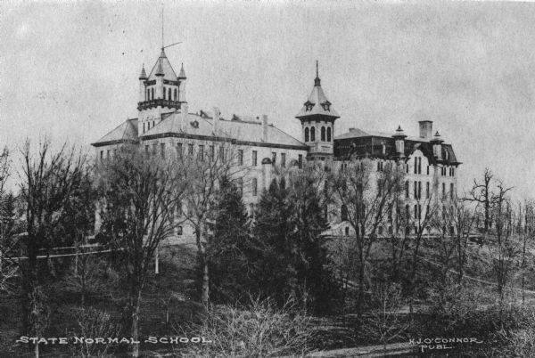 Wisconsin State Normal School located on Main Street in Whitewater. Text reads: Dec. 9 "Dear Duan(??): How would you like to trade schools? This is where I am having lots of fun and work too. I live just across the road from the place where you see the cross." Caption reads: "State Normal School."