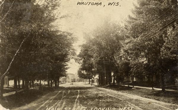 View down center of unpaved street looking west. Captions read: "Wautoma, Wis." and "Main Street Looking West".