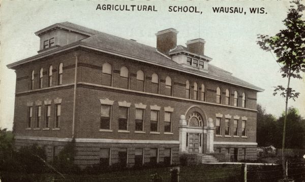 Exterior view of the school. Caption reads: "Agricultural School, Wausau, Wis."