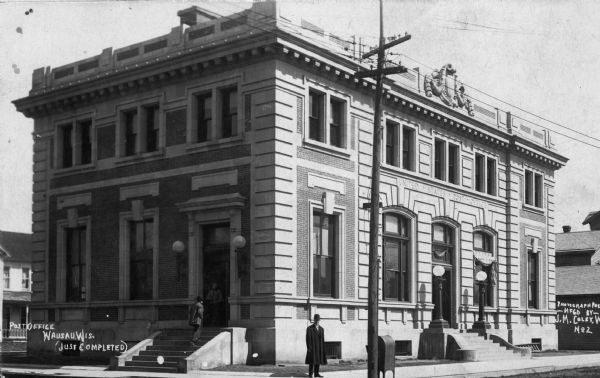 View across street toward the post office just after completion. A man is standing on the sidewalk at the street corner. Caption reads: "Post Office, Wausau, Wis. (Just Completed)."