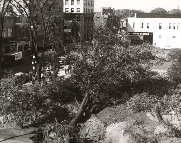 Elevated view of the Marathon County Court House grounds in the foreground. The uprooting of the trees was done in preparation to raze the court house.