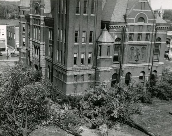 Elevated view of the Marathon County Court House. Felled trees are lying on the ground.