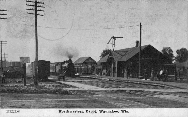 Exterior view of the Northwestern railroad depot with a train approaching the station. Caption reads: "Northwestern Depot, Waunakee, Wis."