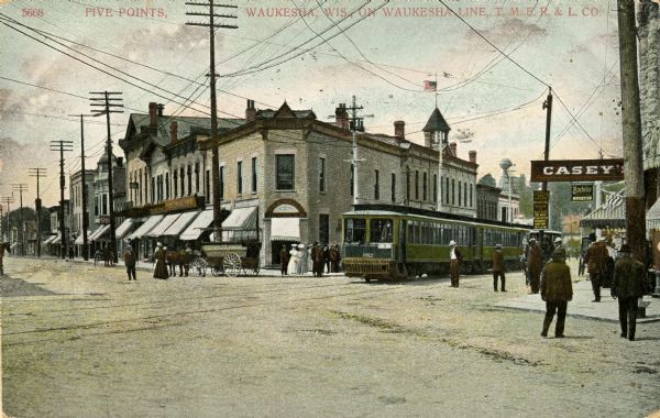 View towards an intersection in downtown Waukesha. Caption reads: "Five Points, Waukesha, Wis, on Waukesha Line, T.M.E.R. & L. Co."