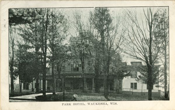 Front view of the Park Hotel, with a child seated in the foreground. Caption reads: "Park Hotel, Waukesha, Wis."