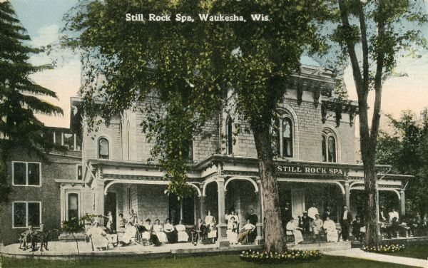 Exterior view of the Still Rock Spa with a group of people gathered on its front porch. Caption reads: "Still Rock Spa, Waukesha, Wis."