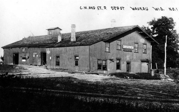 View of the Chicago, Milwaukee, and St. Paul railroad depot. Caption reads: "C. M. and St. P. Depot, Waukau Wis."