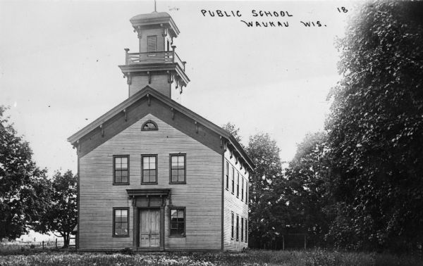 Front view of a public school. Caption reads: "Public School Waukau Wis."