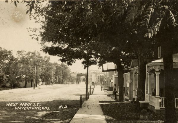 View down sidewalk along the right side of West Main Street. Caption reads: "West Main St., Waterford, Wis."