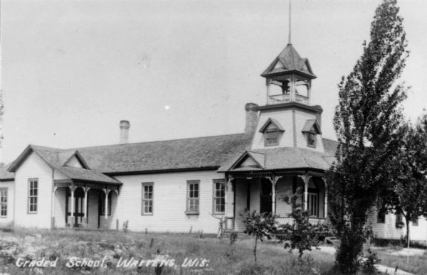 Exterior view of the graded school. There is a bell tower above the entrance. Caption reads: "Graded School, Warrens, Wis."