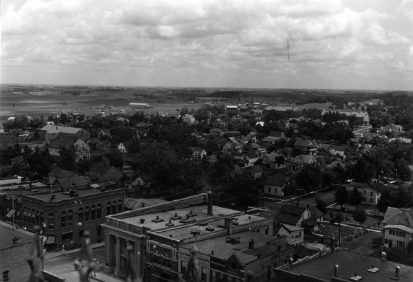 Elevated view of Viroqua. Commercial buildings are in the foreground, with houses among trees in the background.