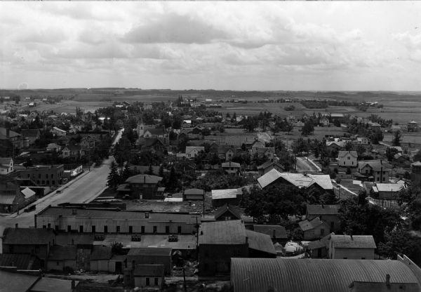 Elevated view over rooftops of Viroqua. Commercial buildings are in the foreground, with a street on the left.