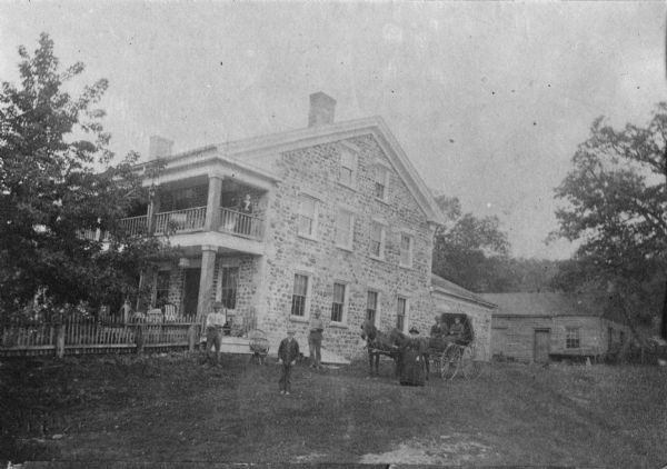 View of the Jessie Smith Tavern, with a group of people and a horse-drawn carriage outside.