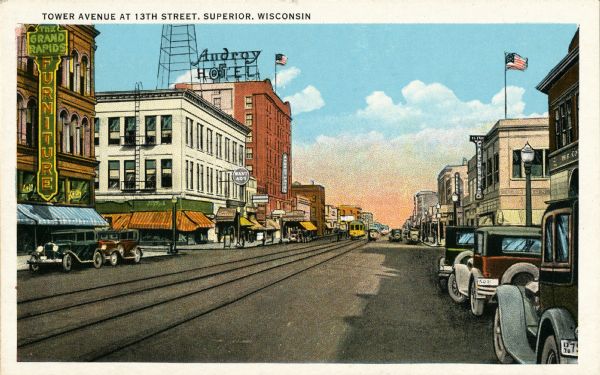 View of Tower Avenue at 13th Street. A furniture store and a hotel are along the left side of the street. Caption reads: "Tower Avenue at 13th Street, Superior, Wisconsin."