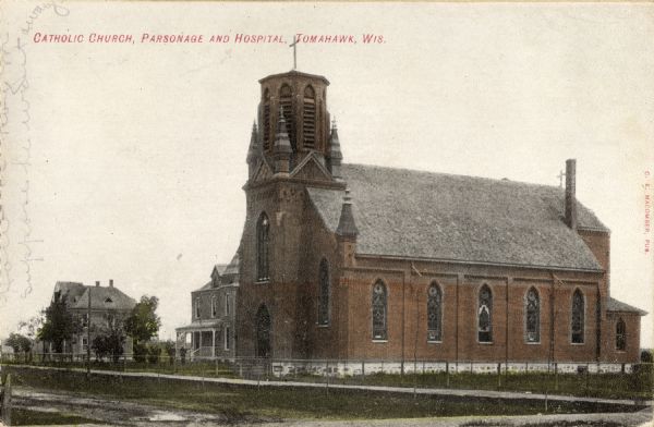 Exterior view of a church, parsonage, and hospital. Caption reads: "Catholic Church, Parsonage and Hospital, Tomahawk, Wis."
