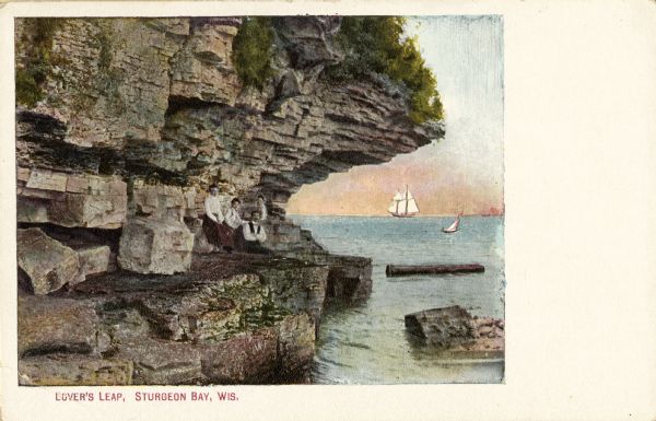 View of Lover's Leap, with a group of people posing on the rocks and sailboats in the background. Caption reads: "Lover's Leap, Sturgeon Bay, Wis."