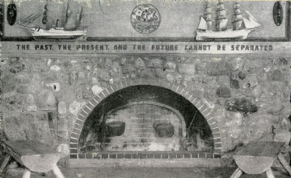 View of the fireplace in the interior of the Door County Museum. The text along the mantel reads: "The Past, The Present, and the Future Cannot Be Separated".