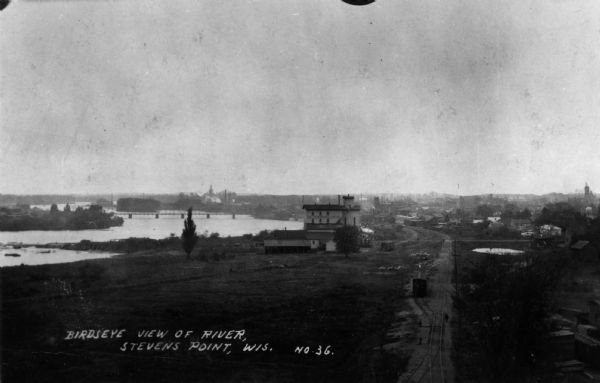 Elevated view of the Jackson Milling Company, the Green Bay railroad tracks, and the Wisconsin Central railroad tracks. Caption reads: "Birdseye View of River, Stevens Point, Wis."