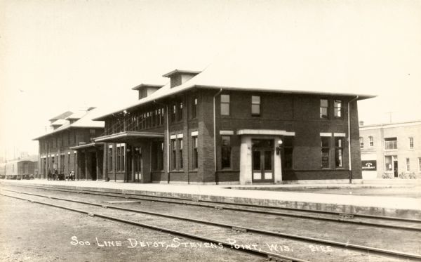 View across railroad tracks towards the Chicago, Milwaukee, & Sault Sainte Marie Railway Depot. In the background on the right is the Star Restaurant. Caption reads: "Soo Line Depot, Stevens Point, Wis."