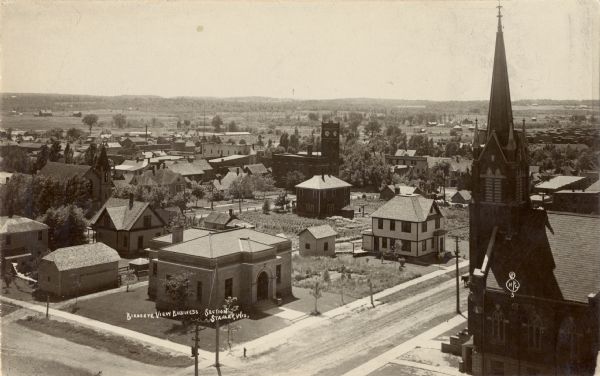 Elevated view of the business section of Stanley, with a church in the right foreground.