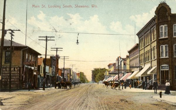 View down center of unpaved street. Caption reads: "Main St., Looking South, Shawano, Wis."
