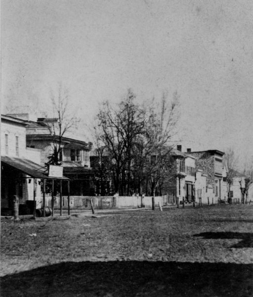 View of unpaved Water Street, showing a millinery shop.