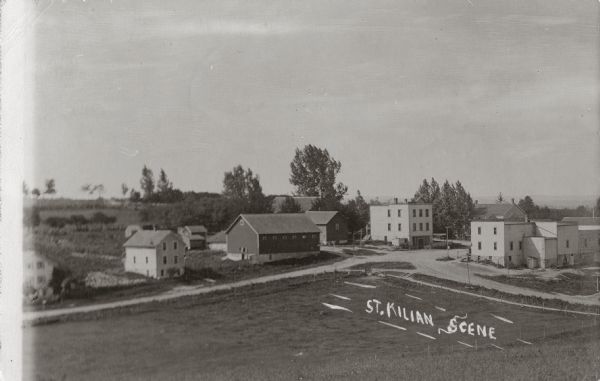 Elevated view from hill looking down towards an intersection and various buildings. Caption reads: "St. Kilian Scene".