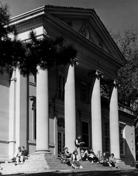 Exterior view of Lane Library at Ripon College, with groups of young people seated on the front steps.