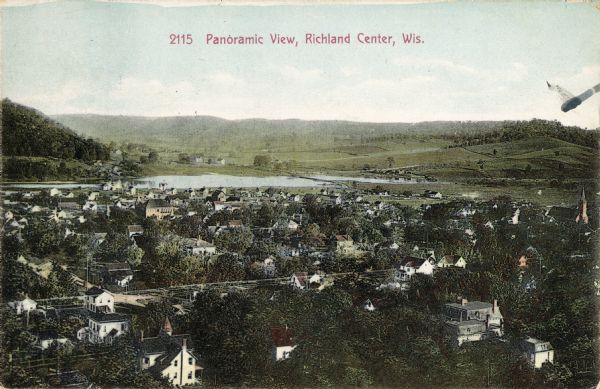 Elevated view of town, with a river and hills in the background. Caption reads: "Panoramic View, Richland Center, Wis."
