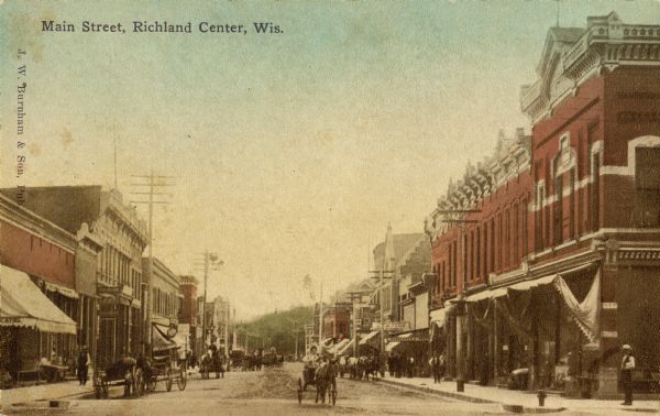 View looking down Main Street, filled with pedestrians and horse-drawn vehicles. Caption reads: "Main Street, Richland Center, Wis."
