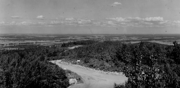 A view from Rib Mountain looking southeast toward Rothschild and the Wisconsin River. The sign on the road in the foreground reads: "Dangerous Road, Drive Slowly."
