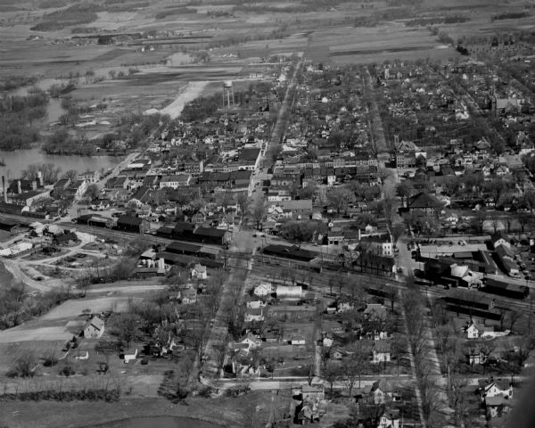 Aerial view of town with multiple buildings and a water tower visible in the background.