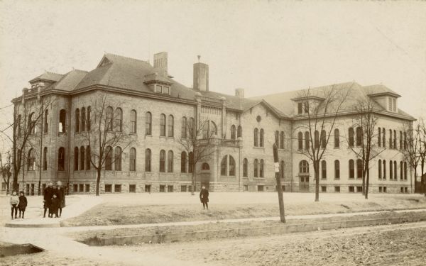 Exterior view from street towards the Washington School, with a group of children standing in front of it.