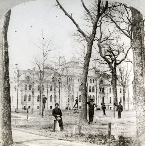 View of individuals standing on the front lawn of Taylor Hall on the campus of Racine College.