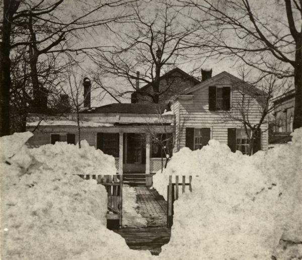 Winter scene of the H. Stone residence, with the front yard piled high with snow.