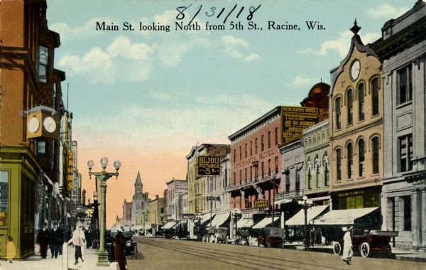 View down sidewalk on left side of street. Caption reads: "Main St. looking North from 5th St., Racine, Wis."